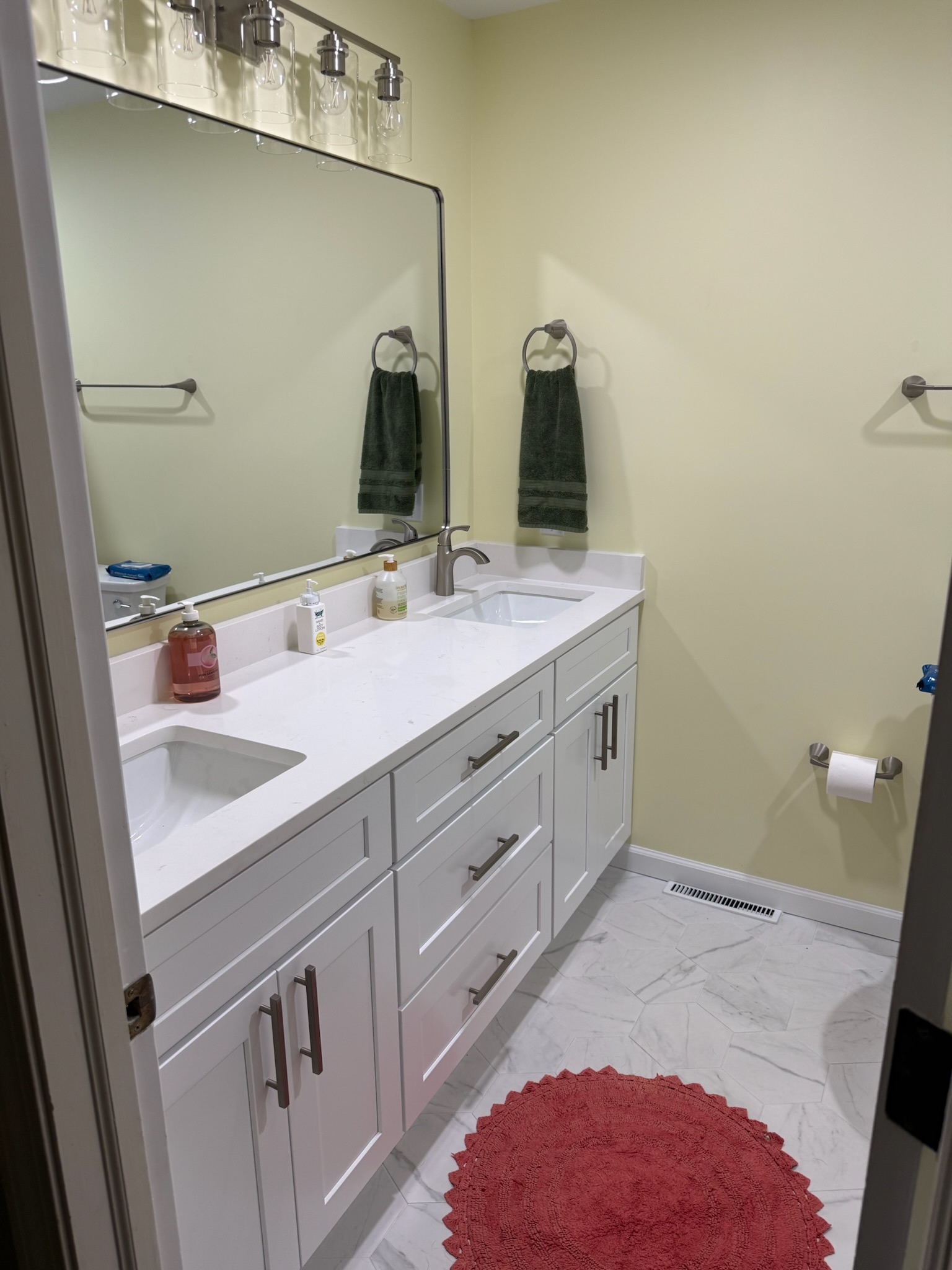 Hall bathroom remodel in Anderson, SC with quartz-topped vanity, framed mirror, and hexagon tile floor - Brett J. project photo 1