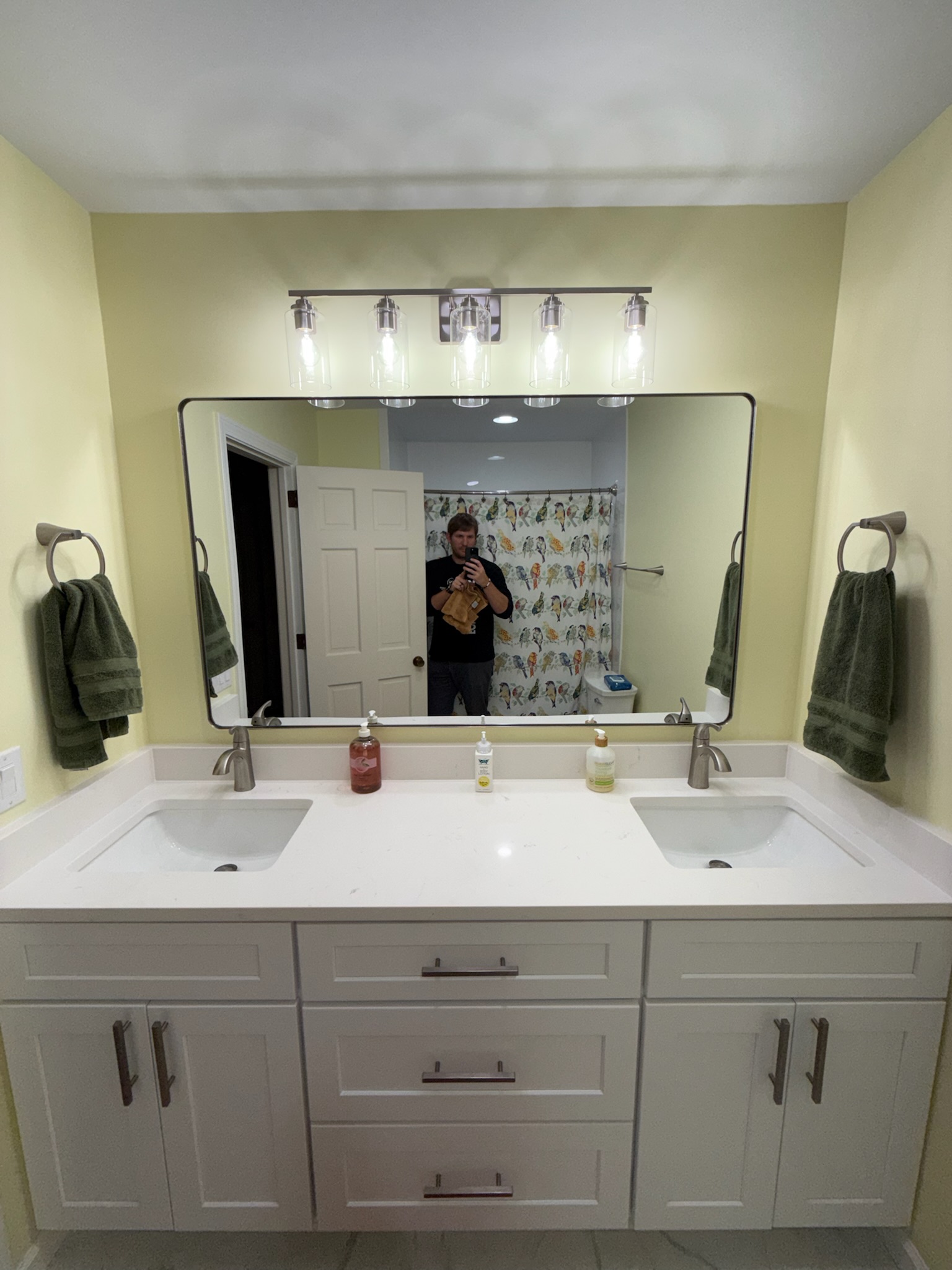 White shaker double-sink vanity with white quartz countertop and five-bulb vanity light in Upstate SC bathroom